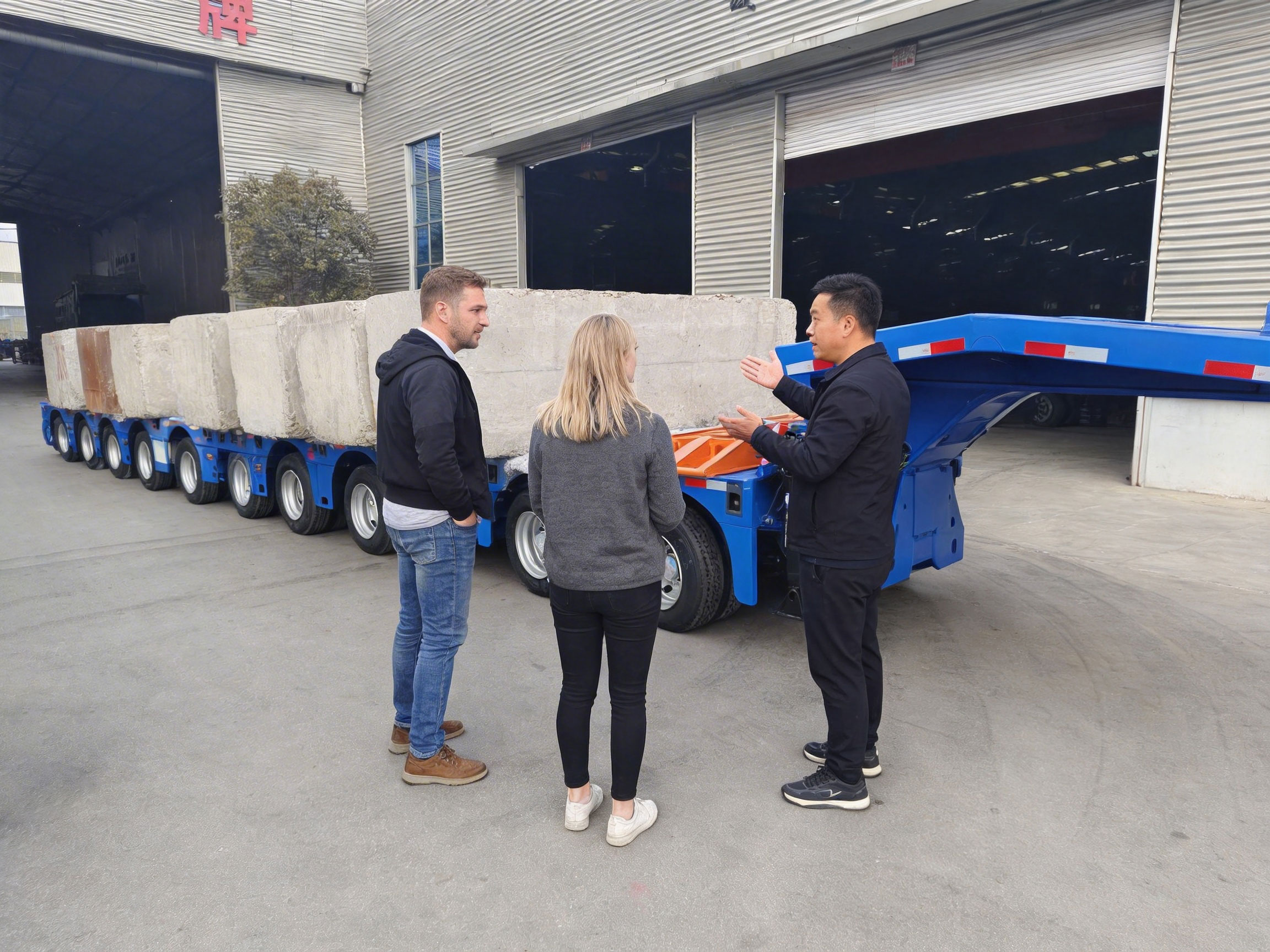 Foreign clients inspecting the HUAYUE 10 axle extendable lowbed trailer during a maximum payload test at the factory