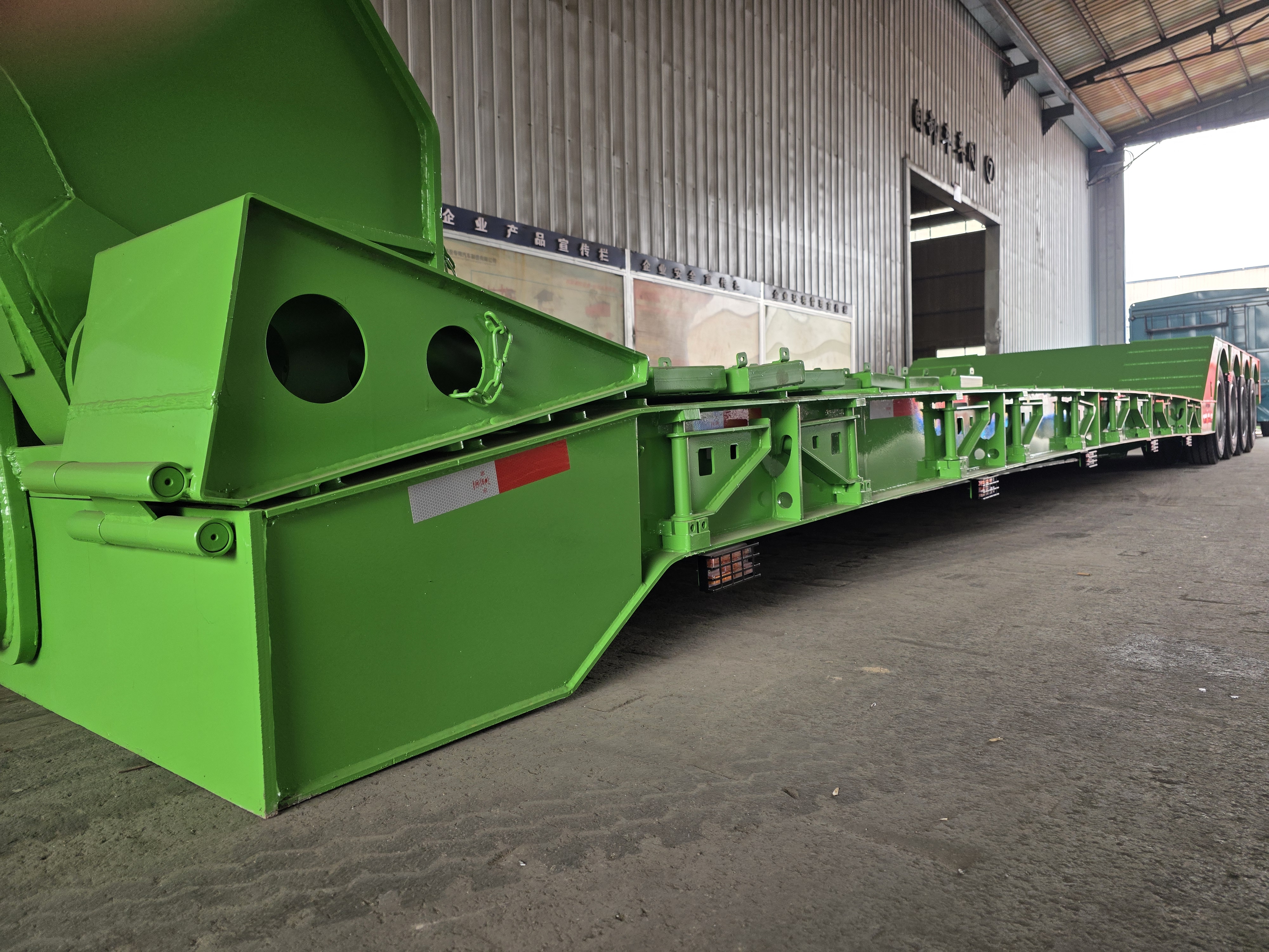 Close-up view of the integrated heavy-duty steel climbing ladder on the front of the HUAYUE 4 axle 100 ton removable gooseneck trailer for safe crew access