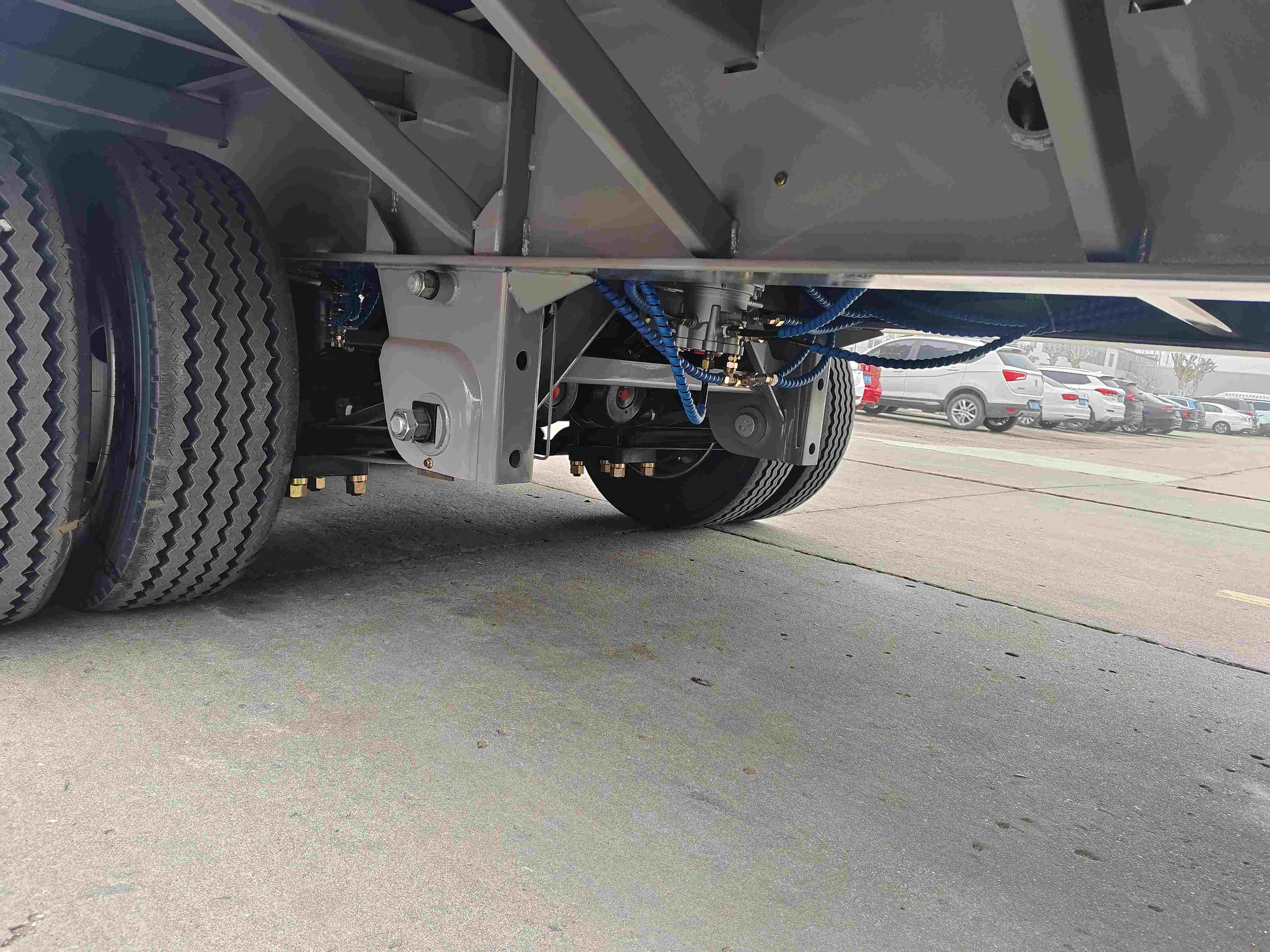 Close-up of the heavy-duty chassis, suspension, and pneumatic brake system on the 3 axle curtain side trailer