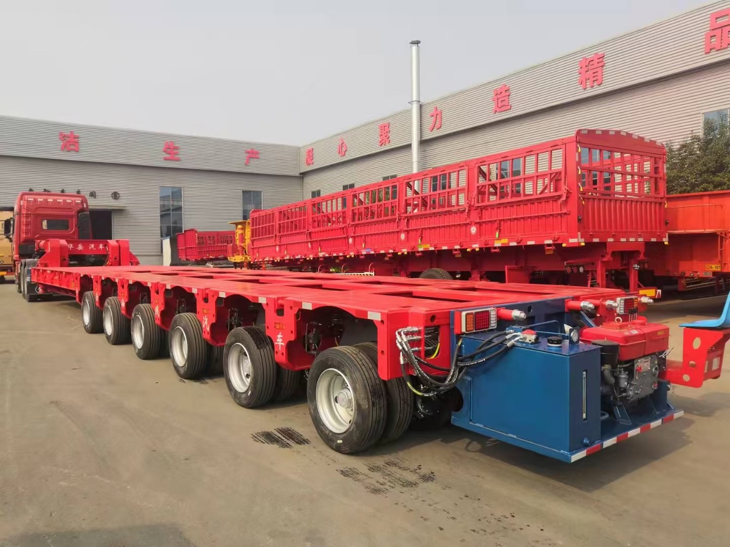 Rear-side view of the fully assembled multi-axle hydraulic modular trailer, showcasing the integrated power pack unit and robust chassis ready for transport