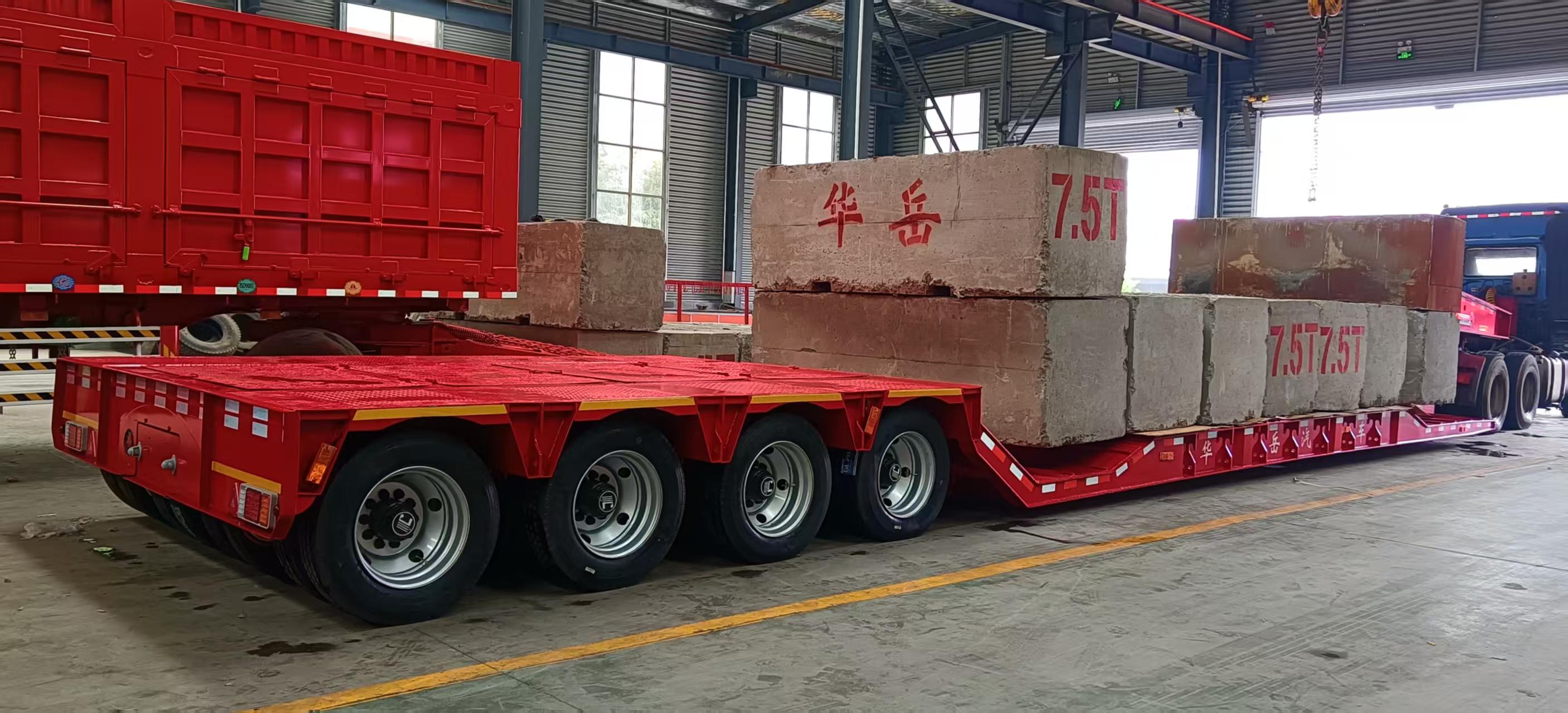 Rigorous factory load testing of the HUAYUE hydraulic modular trailer, loaded with massive concrete blocks to ensure structural integrity and perfect axle load distribution for heavy infrastructure projects.
