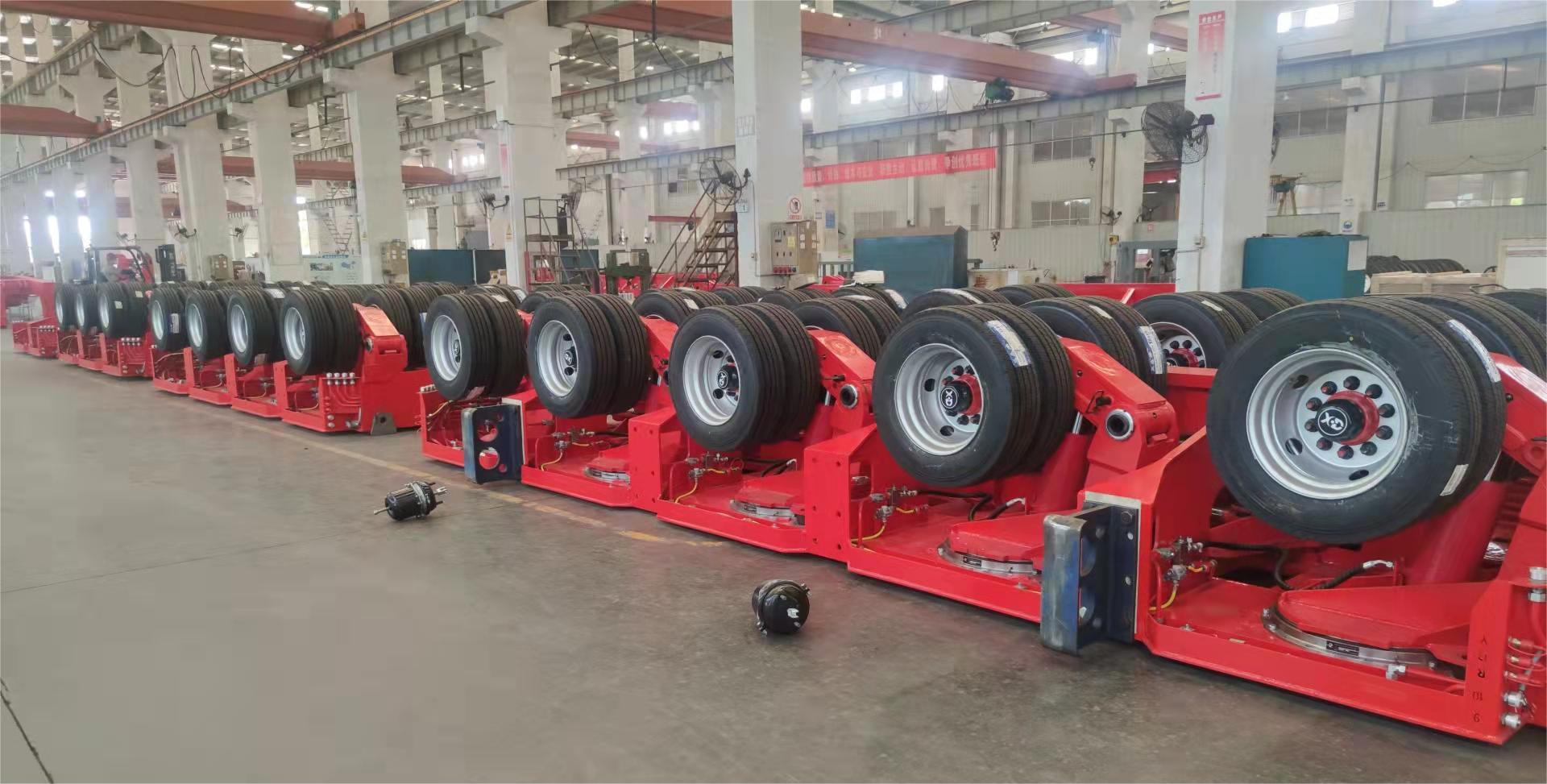 Inside the HUAYUE manufacturing facility: A long row of heavy-duty hydraulic suspension and axle modules, ready to be assembled into customized modular transporters to guarantee compliant axle weights