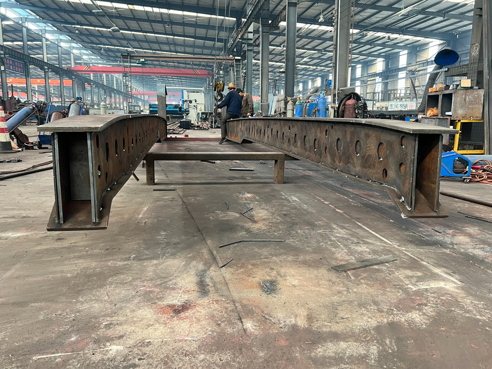 Close-up of the HUAYUE RGN trailer's reinforced high-strength steel main beam and heavy-duty suspension, engineered for extreme payloads