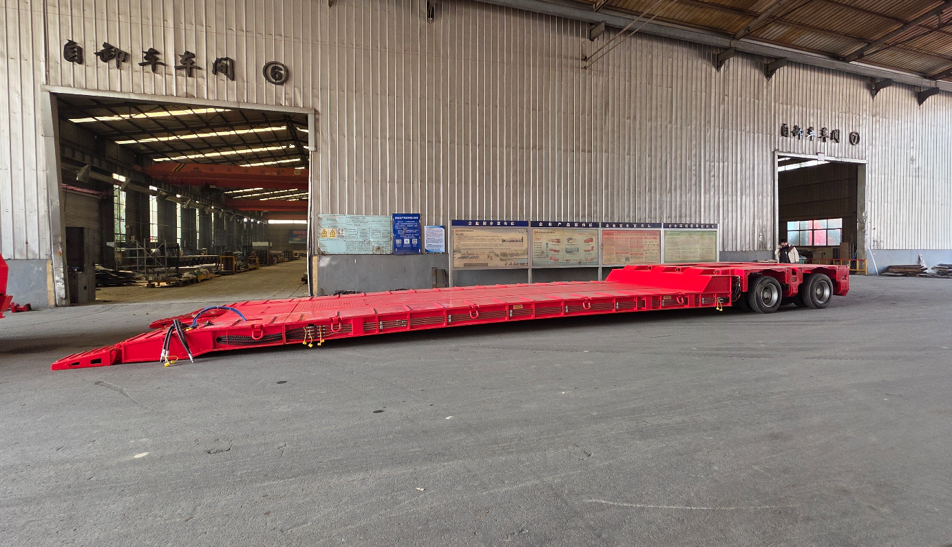 HUAYUE RGN lowbed trailer with the hydraulic gooseneck detached, showing the main deck lowered flat to the ground to form an extremely safe front-loading ramp for heavy crawler excavators.