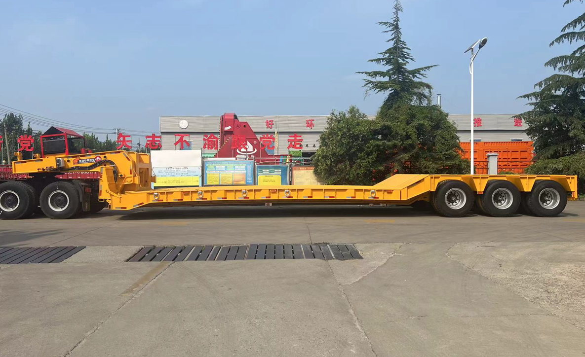 Side profile of HUAYUE 3-axle hydraulic removable gooseneck (RGN) lowbed trailer in industrial yellow, specifically engineered for front-loading heavy construction equipment.