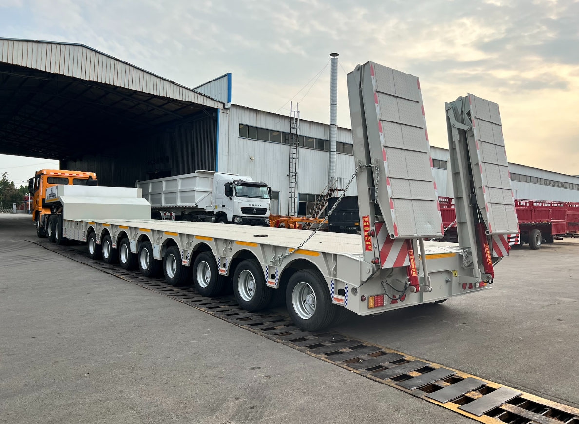 Rear perspective of the HUAYUE 8-axle heavy-duty lowbed trailer, displaying the deployed heavy-duty double-folding hydraulic ramps that provide an ultra-low-angle loading corridor.