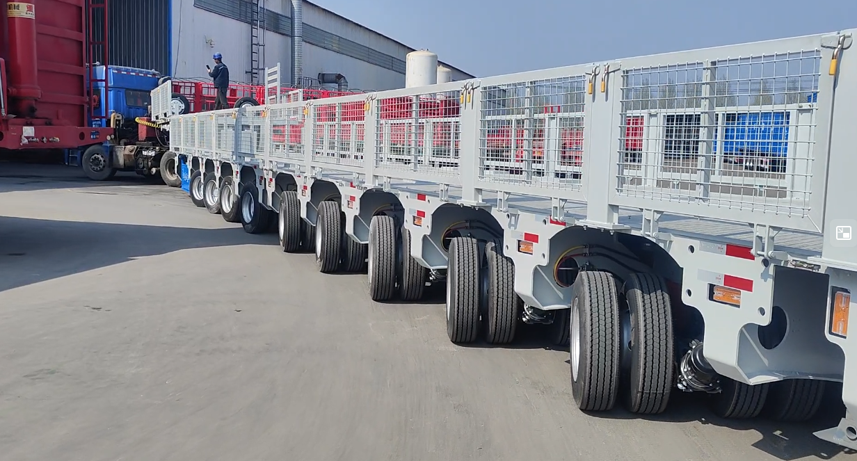 Close-up of the hydraulic suspension and steering wheelsets on a HUAYUE multi-axle trailer. Precise hydraulic circuits ensure the wheelsets follow the steering trajectory even under extreme heavy loads.