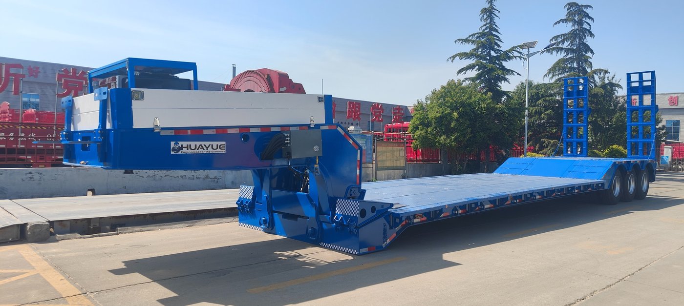 A bottom-up shot of the lowbed trailer showing the dense, high-strength cross-members welded between the main beams, or a close-up of a heavy tracked machine resting securely on the reinforced deck.