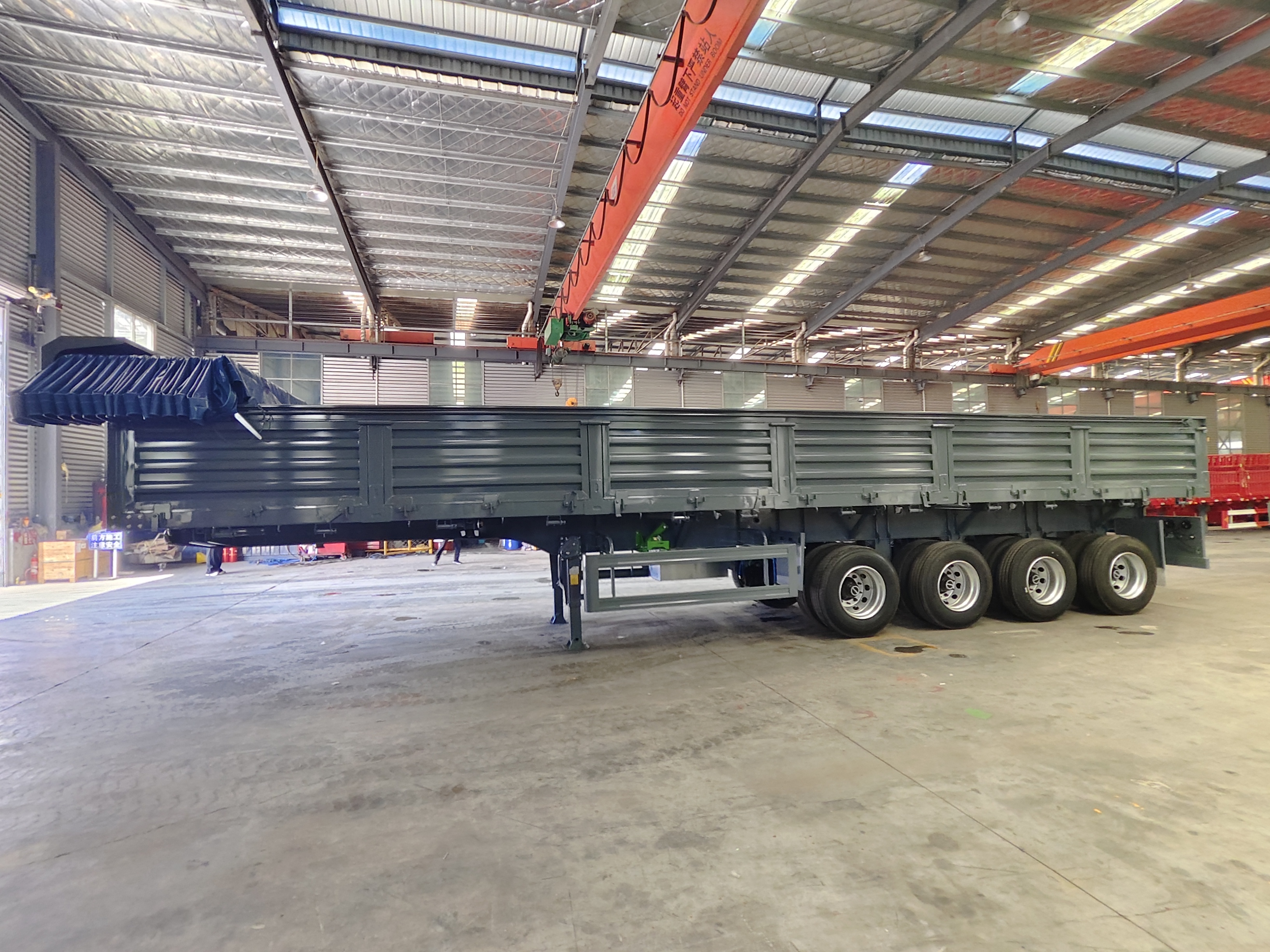 A fully loaded heavy-duty dump semi-trailer navigating brutal mining road conditions, demonstrating the high-intensity load and stability challenges.