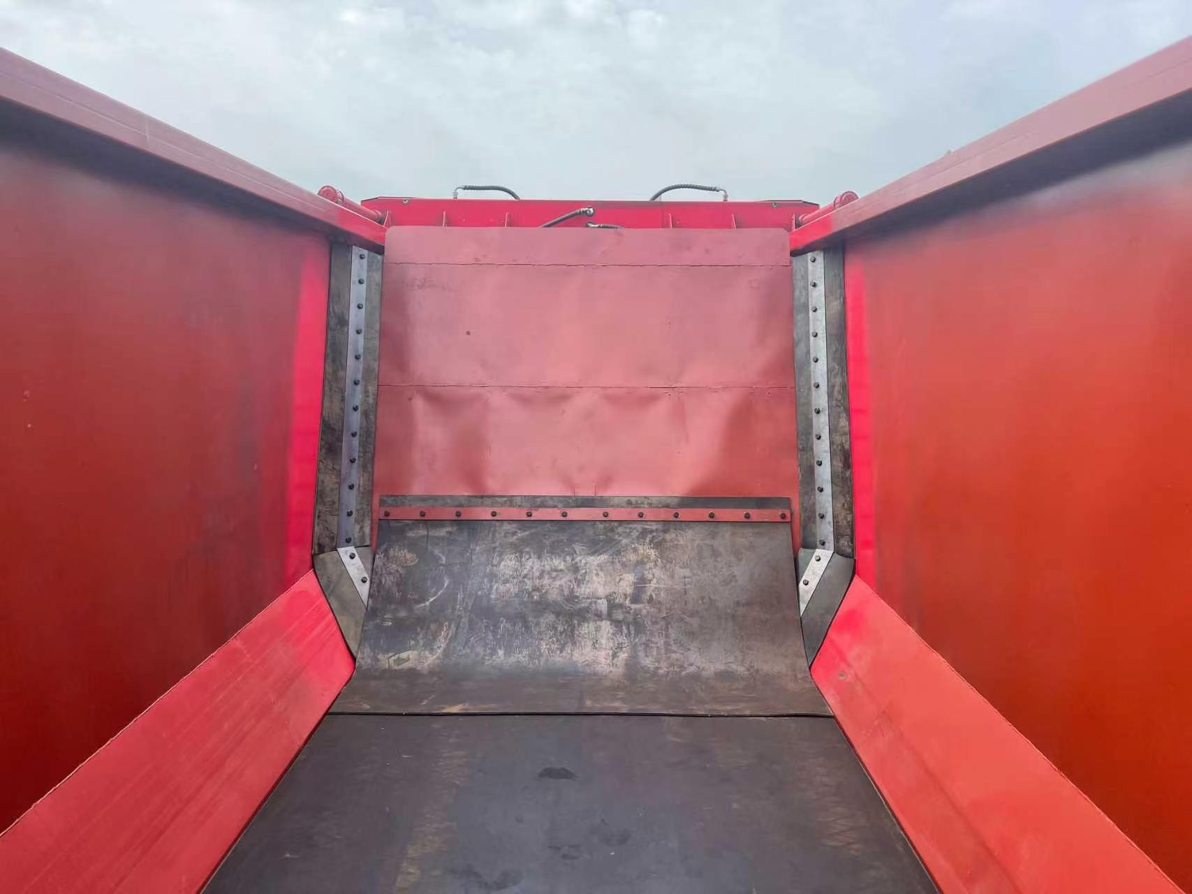 Interior of a red bulk-material body with a conveyor discharge floor