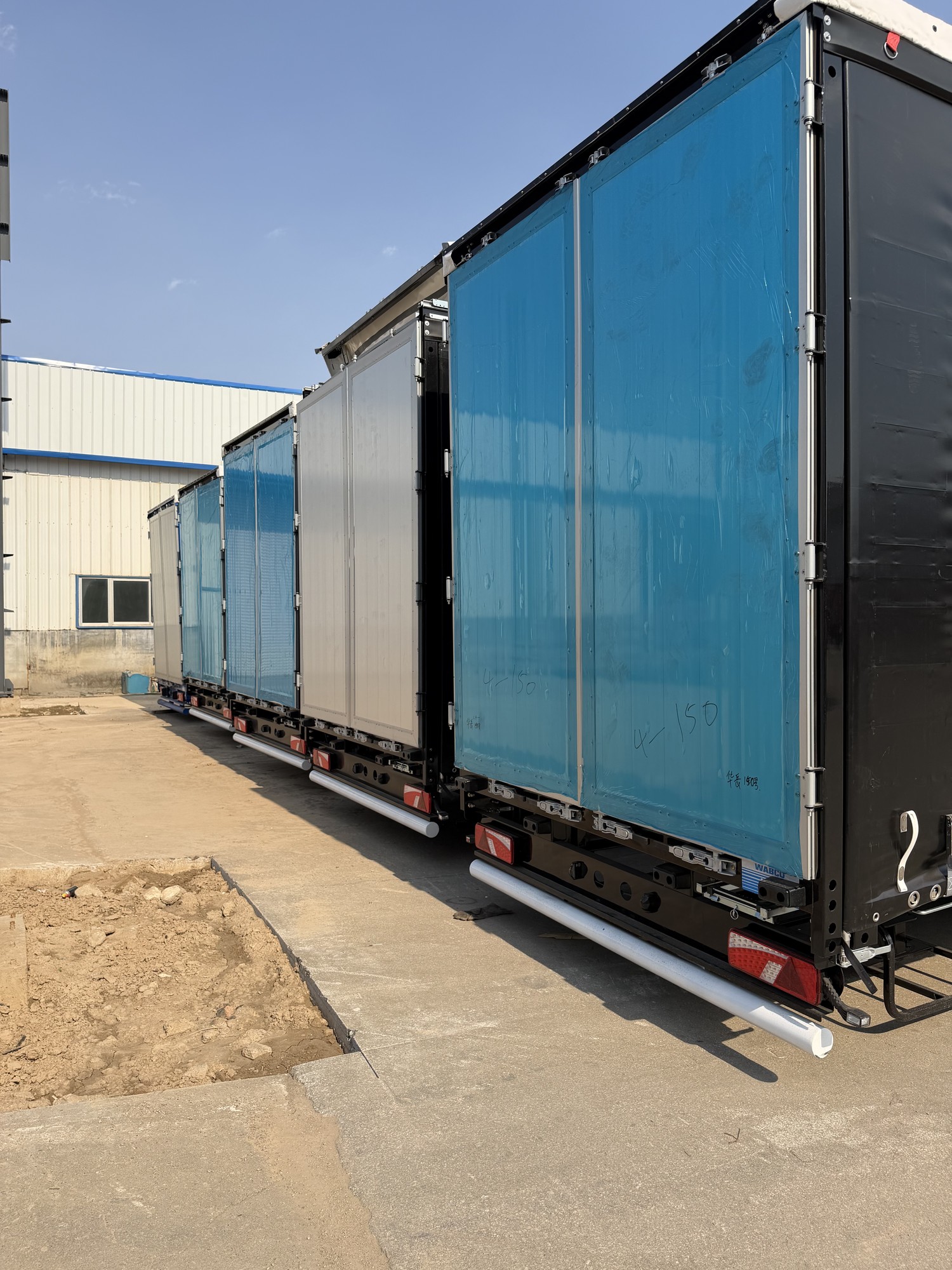 Curtain side trailer body views Rear views of curtain side semi-trailers with blue and silver curtain panels